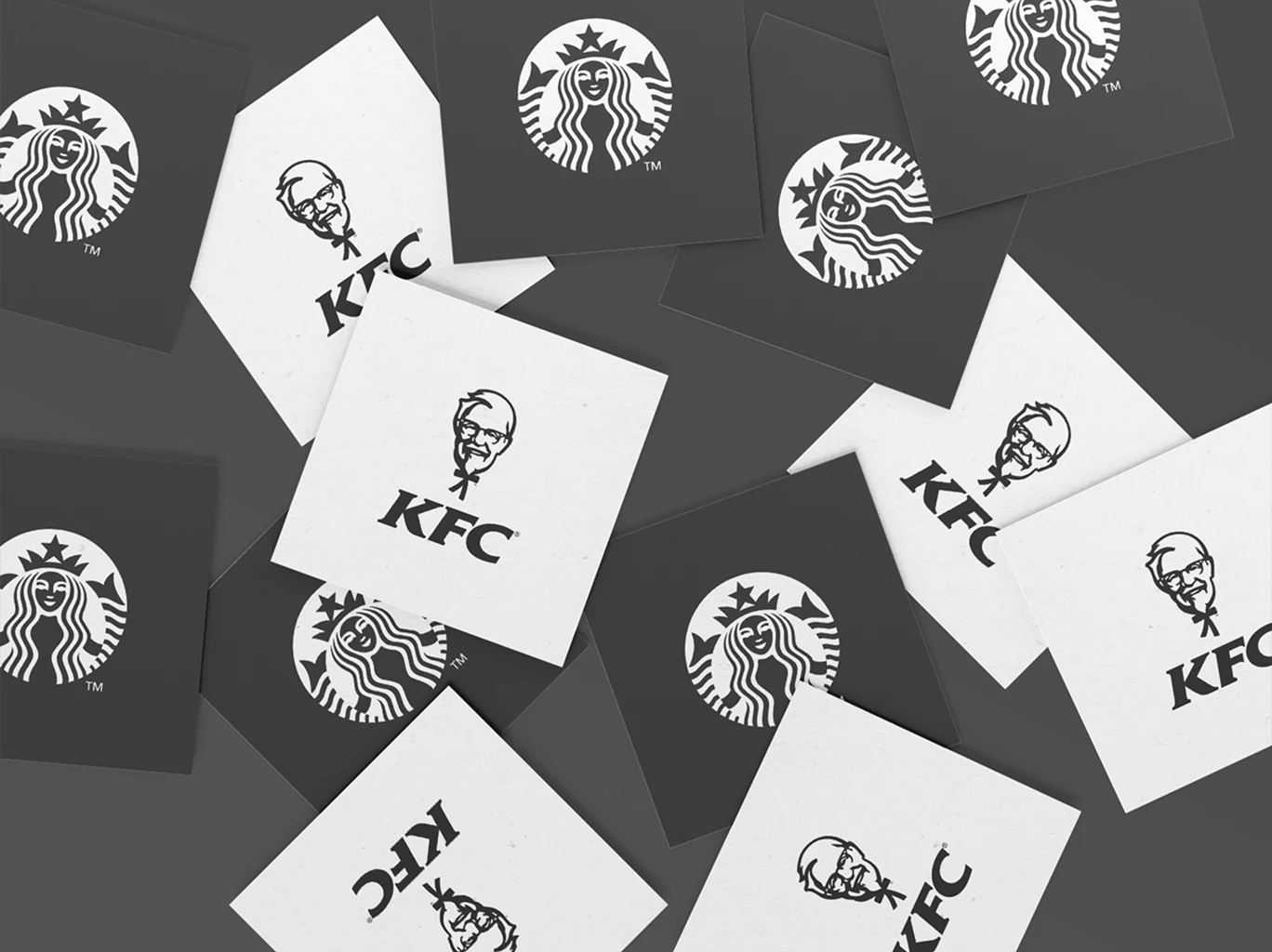 A scattered arrangement of monochrome square cards featuring black-and-white versions of the KFC and Starbucks logos on a dark gray background. The cards are rotated at different angles, creating a layered, mockup-style presentation that highlights the logo designs.